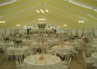 Hochzeitszelt, 21 m Zeltbreite mit händenden Dekorationsbahnen gelb-weiß und runder Bestuhlung